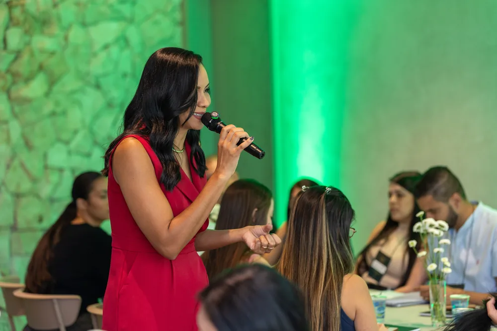 Daniela Rocha ao microfone diante do público.