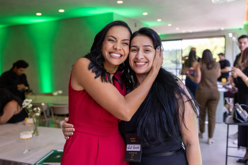 Daniela Rocha e uma participante, rosto a rosto, sorrindo.